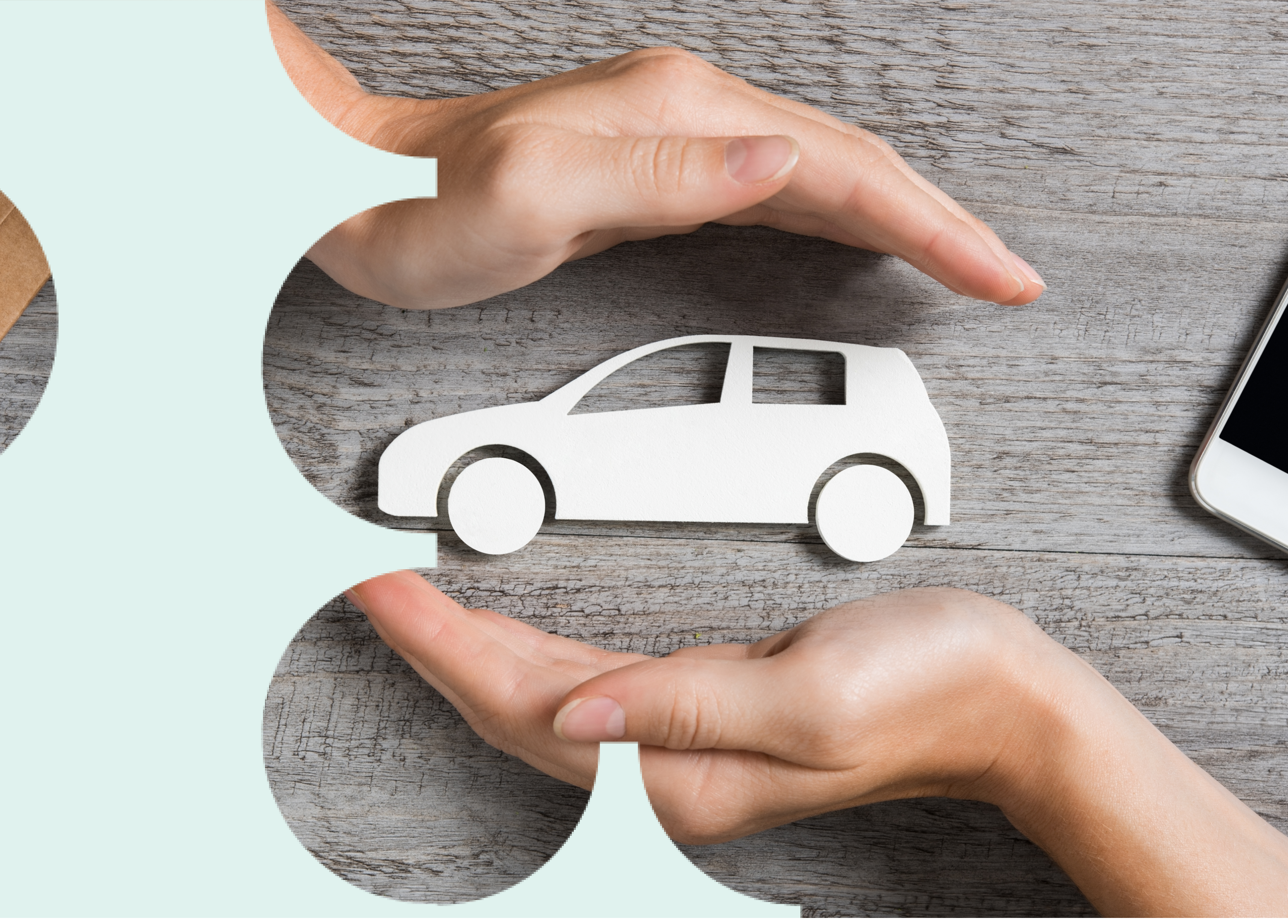 Duas mãos em torno de um carro de papel, em sinal de proteção